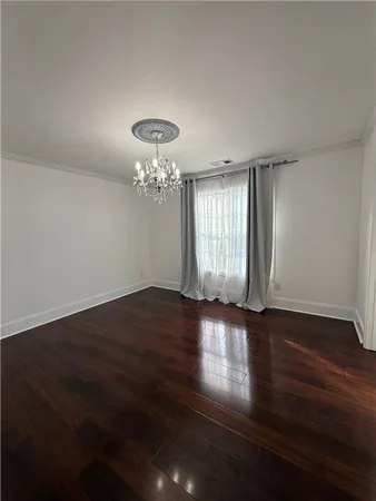 a view of a hallway with wooden floor and entryway