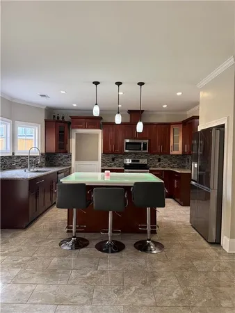 a large kitchen with granite countertop a sink and dishwasher a stove top oven with wooden floor