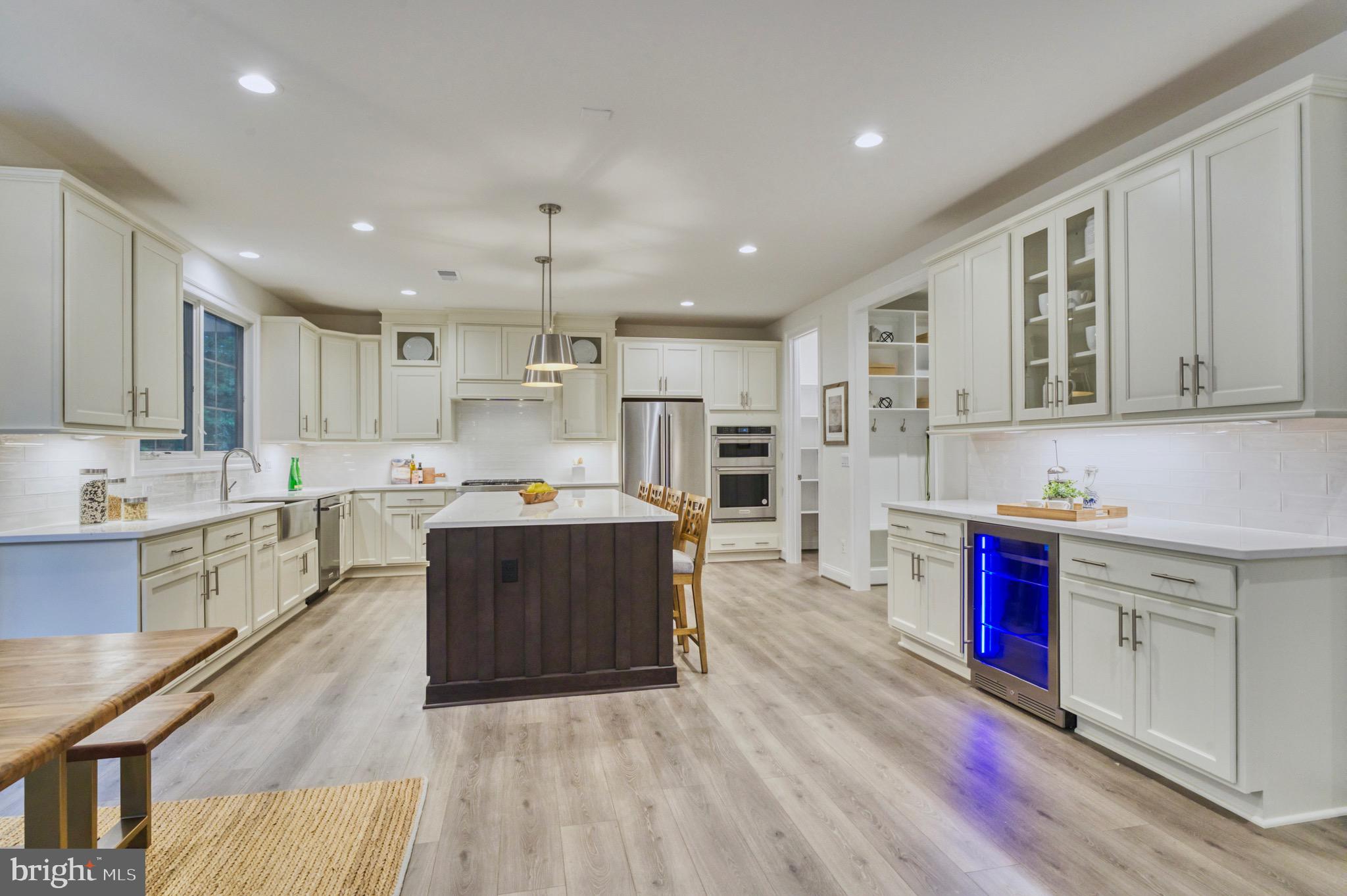 2236 Laurel Ridge Road Vienna, VA 22181 - Photo 22 of 78 a large kitchen with stainless steel appliances kitchen island granite countertop a stove a sink a refrigerator and white cabinets