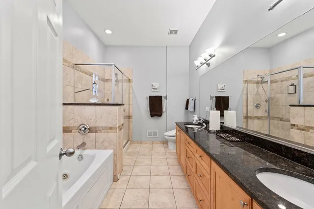 a spacious bathroom with a granite countertop double sink and mirror