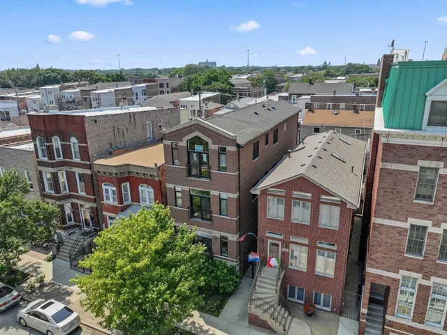 an aerial view of residential houses with yard and parking space
