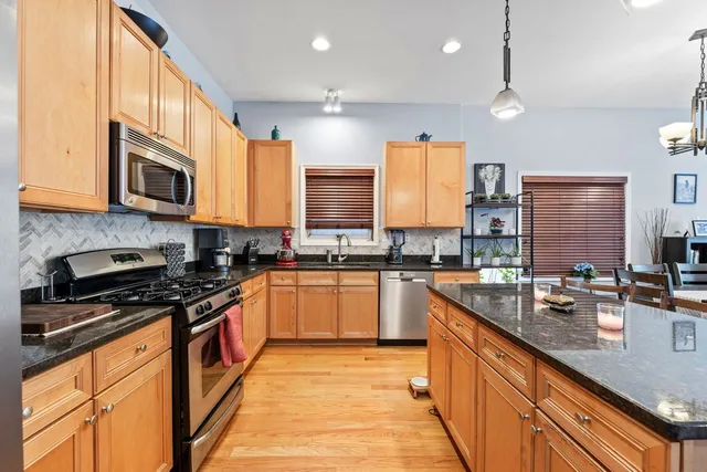 a kitchen with stainless steel appliances granite countertop a stove a sink and a microwave