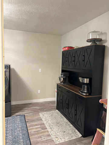 1324 West Raintree Drive, Unit 44 Price, UT 84501 - Photo 13 of 25 Dedicated utility space featuring a wood-finish flooring, light tan walls, and a built-in black cabinetry unit with a wood countertop