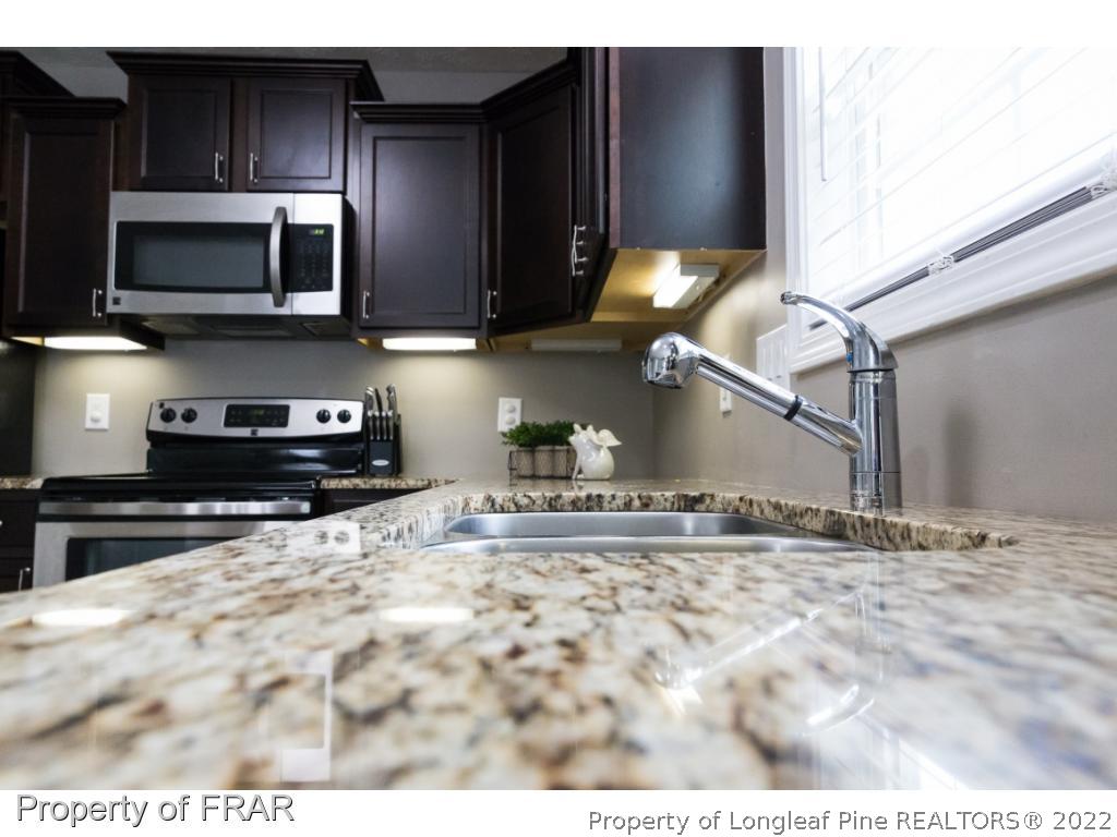 664 Cape Fear Road Raeford, NC 28376 - Photo 12 of 36 a kitchen with stainless steel appliances granite countertop a sink and a stove top oven