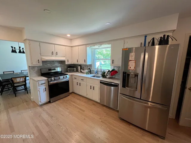 a kitchen with stainless steel appliances a refrigerator stove microwave and sink