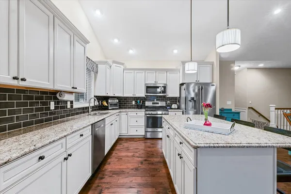 a kitchen with kitchen island granite countertop lots of counter top space and stainless steel appliances