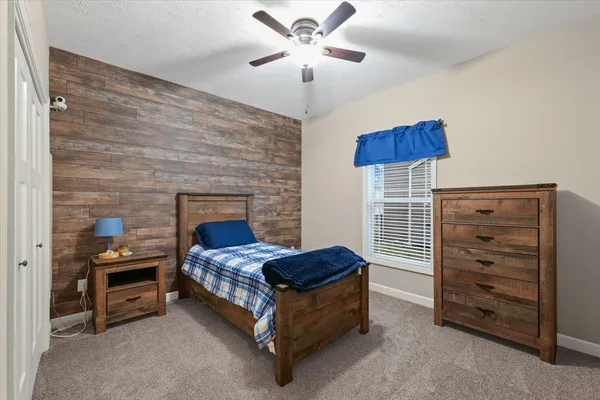 a bedroom with a bed and a ceiling fan