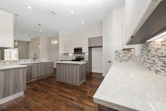 a kitchen with a sink a counter top space stainless steel appliances and cabinets