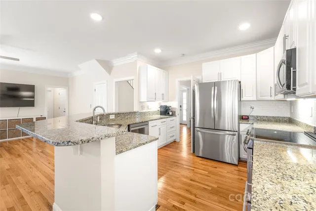a kitchen with stainless steel appliances granite countertop a refrigerator and a sink