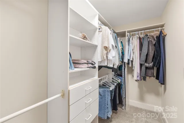 a view of walk in closet with clothes