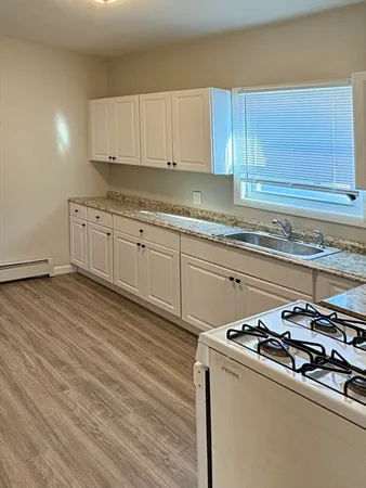 a kitchen with granite countertop a stove and a sink