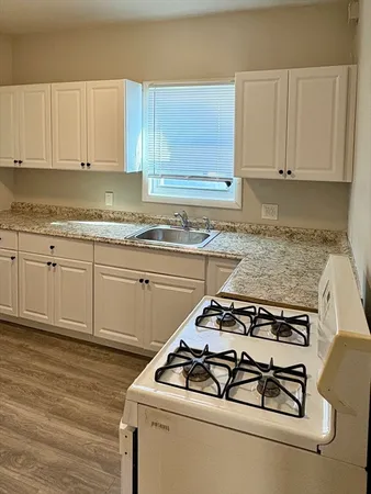 a white stove top oven sitting inside of a kitchen