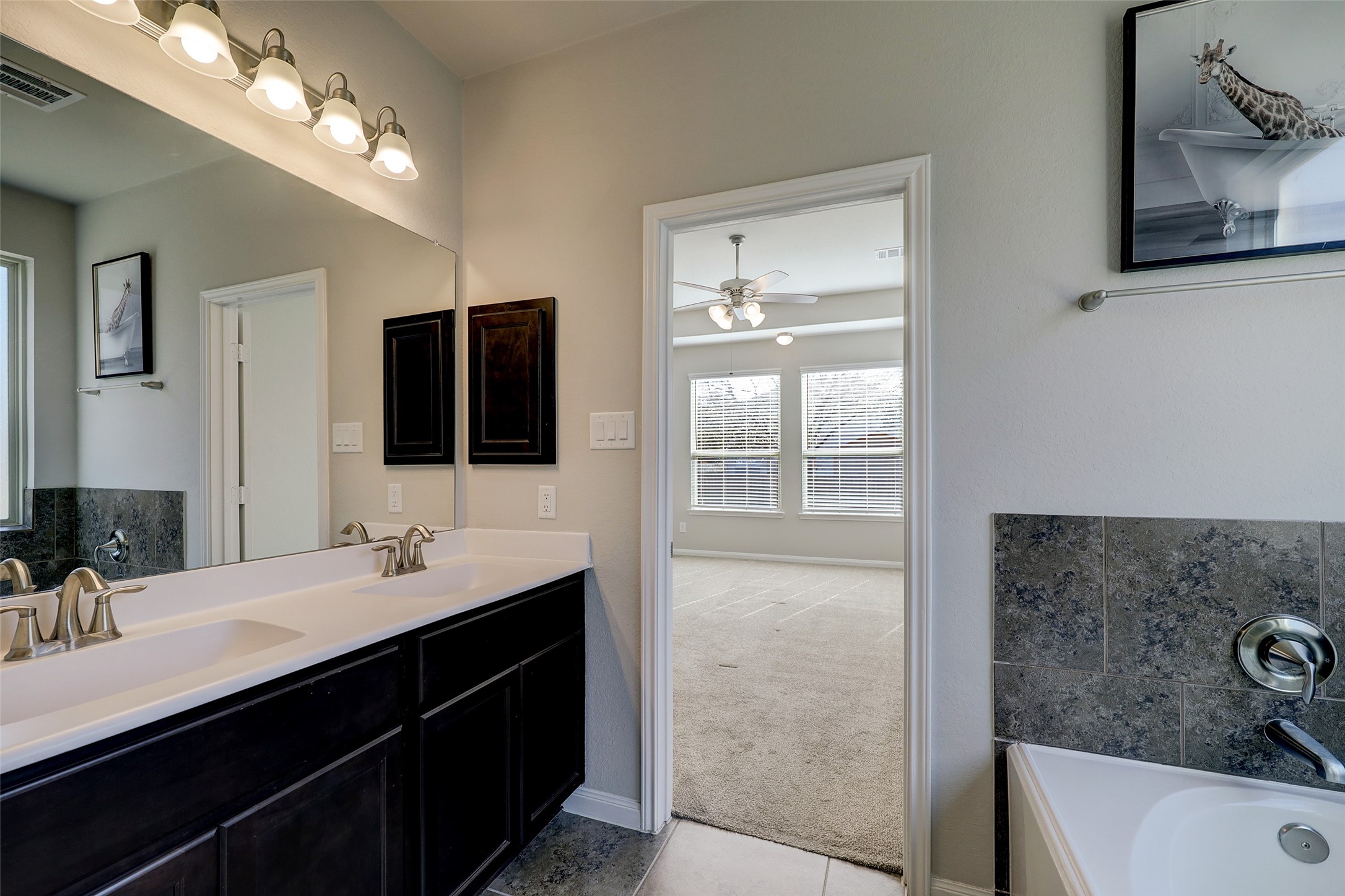 314 Moonwalk Street Montgomery, TX 77356 - Photo 12 of 21 a bathroom with a double vanity sink a large mirror and a shower