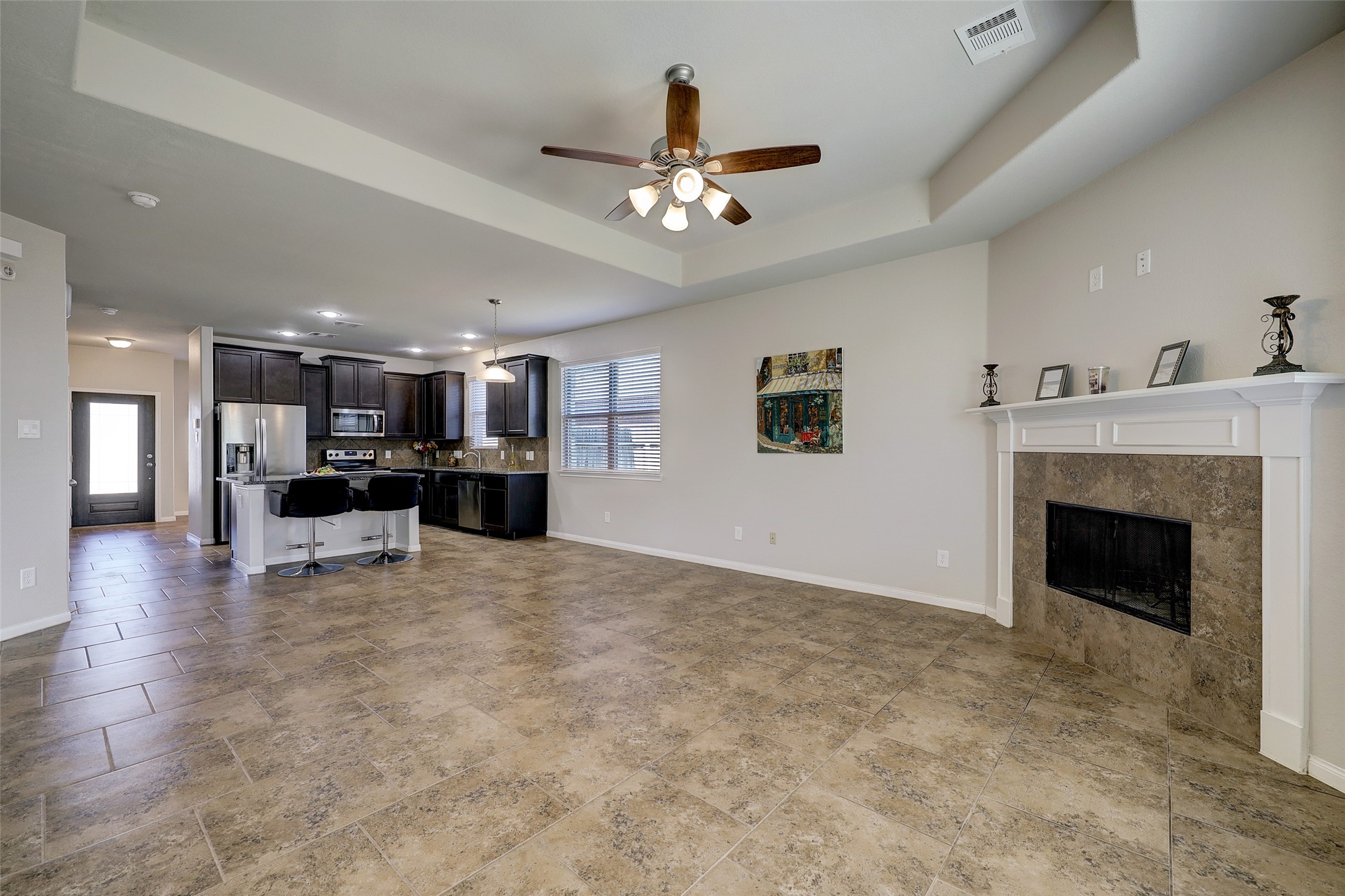 314 Moonwalk Street Montgomery, TX 77356 - Photo 6 of 21 a view of an empty room and kitchen with fireplace ceiling fan