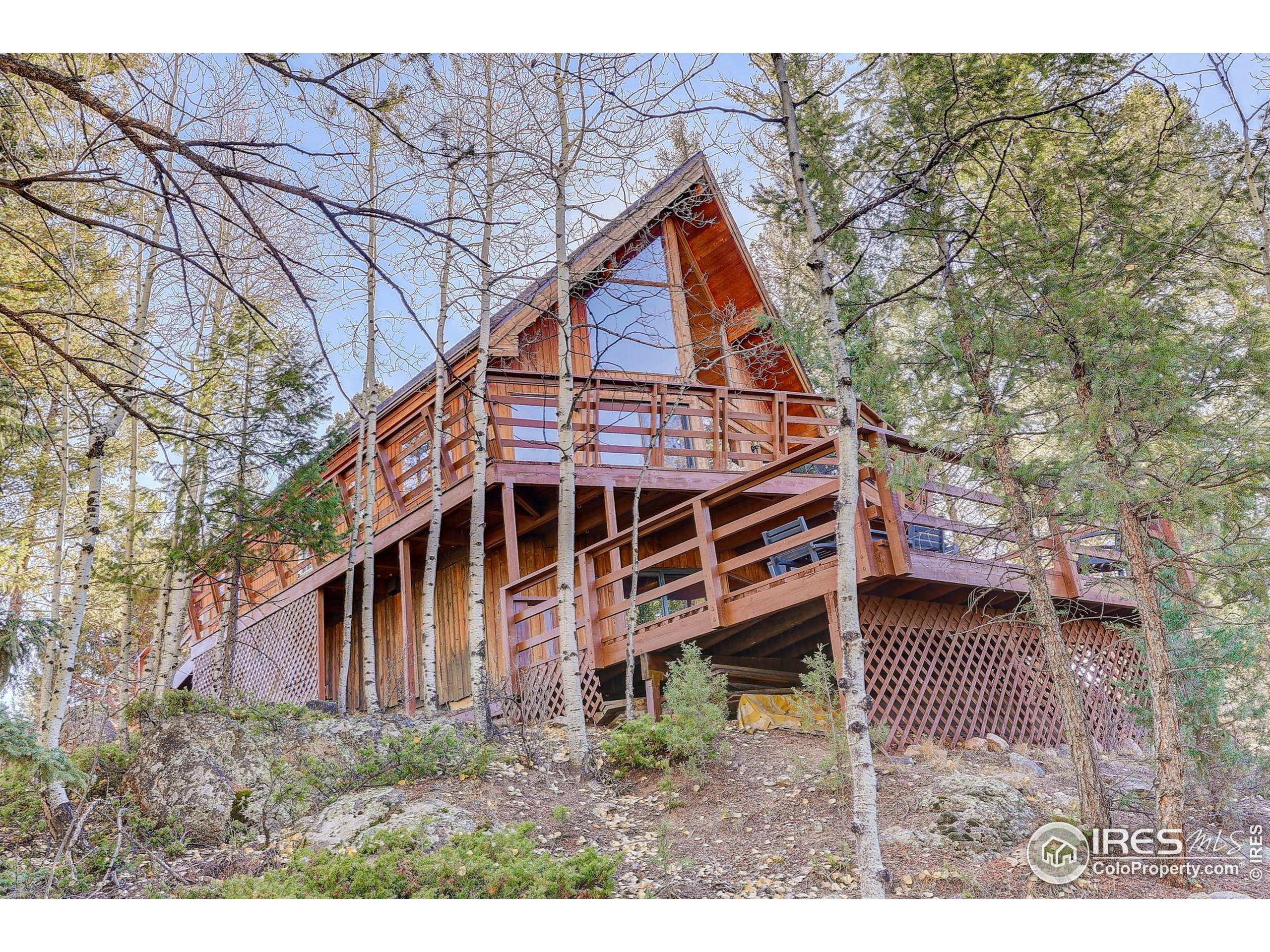 211 Hi Meadow Drive Bailey, CO 80421 - Photo 3 of 19 a view of house with a yard and wooden fence