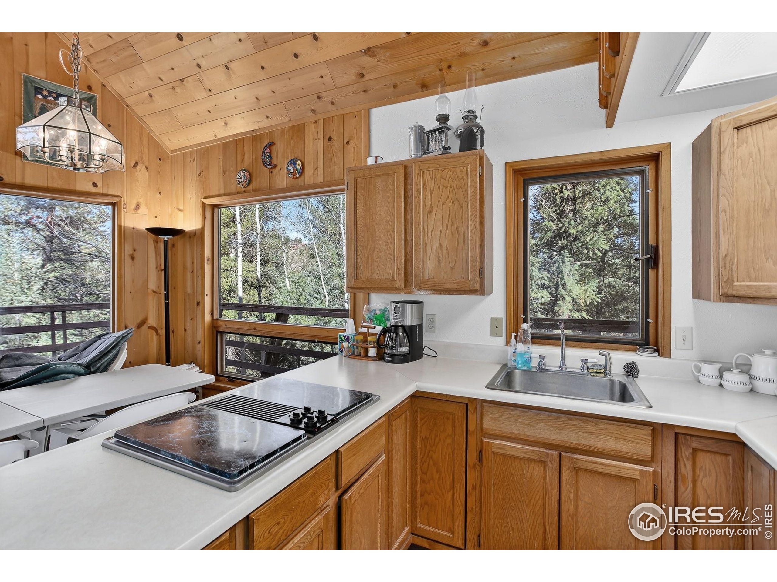 211 Hi Meadow Drive Bailey, CO 80421 - Photo 9 of 19 a kitchen with a sink window and cabinets
