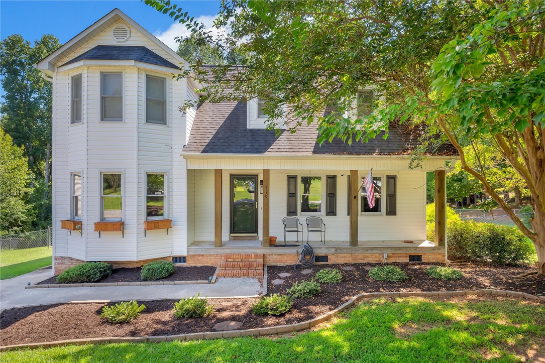A welcoming front porch with wooden columns highlights this classic two-story exterior.