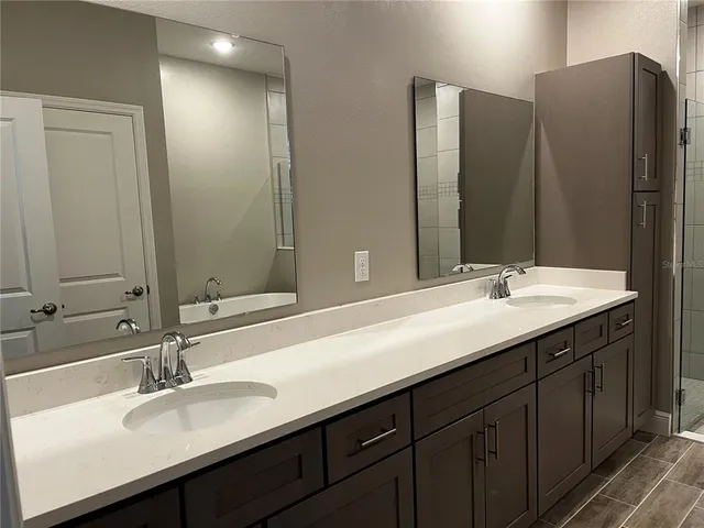 a bathroom with double sink and a mirror