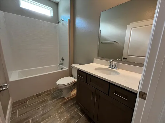 a bathroom with a sink toilet vanity and shower
