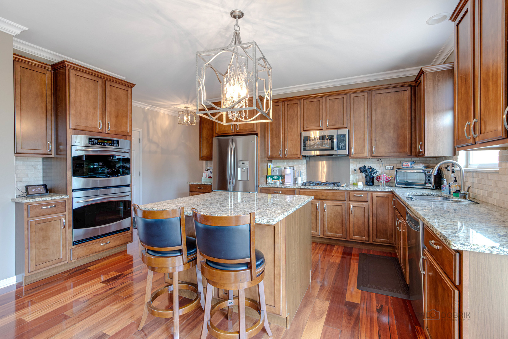 2688 Reedgrass Way Wauconda, IL 60084 - Photo 11 of 27 a kitchen with stainless steel appliances granite countertop a kitchen island hardwood floor sink stove dining table and chairs