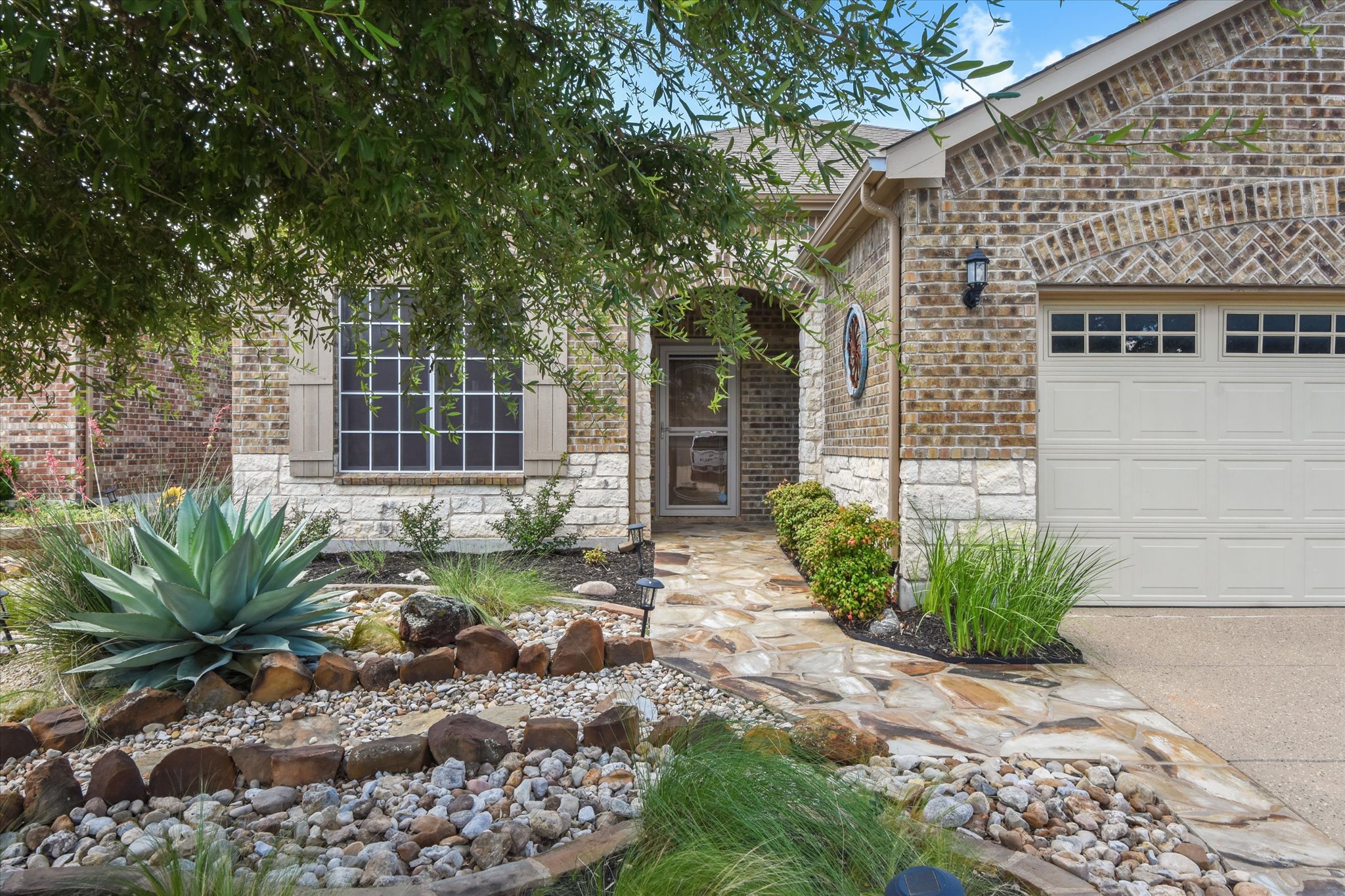 104 Coffee Mill Creek Road Georgetown, TX 78633 - Photo 1 of 40 A flagstone walkway leads to the welcoming covered front entry, surrounded by beautifully landscaped xeriscaping designed for low maintenance living.