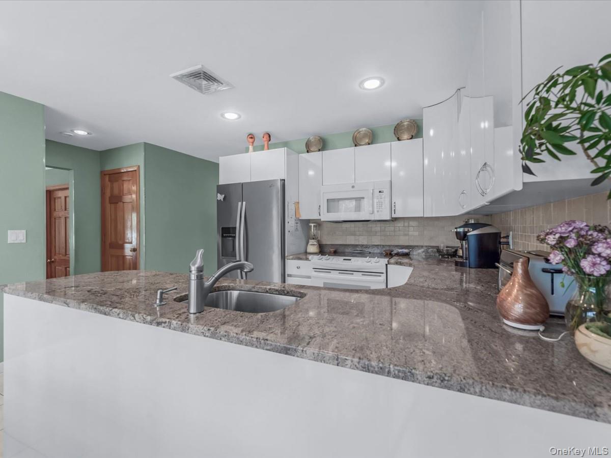 29 Sun Hill Road Nesconset, NY 11767 - Photo 5 of 32 a kitchen with stainless steel appliances kitchen island granite countertop a sink and cabinets