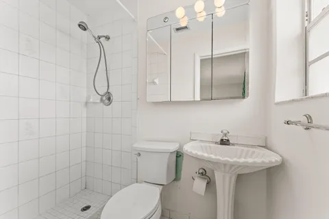 a bathroom with a sink a toilet and shower