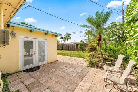 a view of backyard with wheel chair potted plants and large tree
