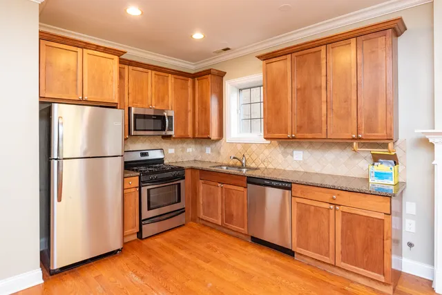 a kitchen with stainless steel appliances granite countertop a refrigerator sink and cabinets