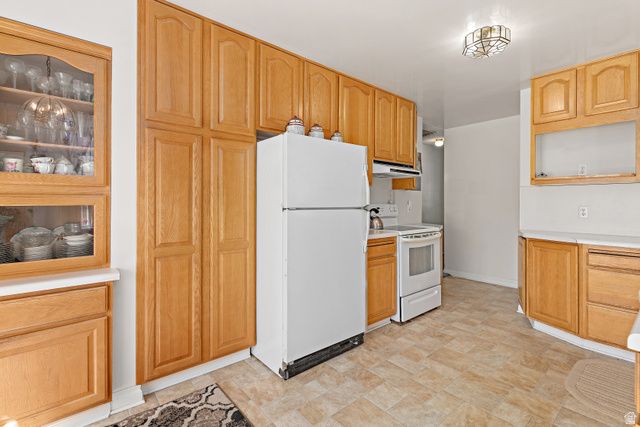 664 Wasatch Street Midvale, UT 84047 - Photo 8 of 33 Wood-finish cabinetry with glass-front display, white countertops, and tiled flooring