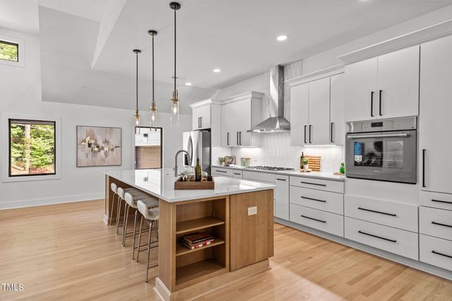 a kitchen with stainless steel appliances granite countertop a refrigerator a stove a sink and a refrigerator