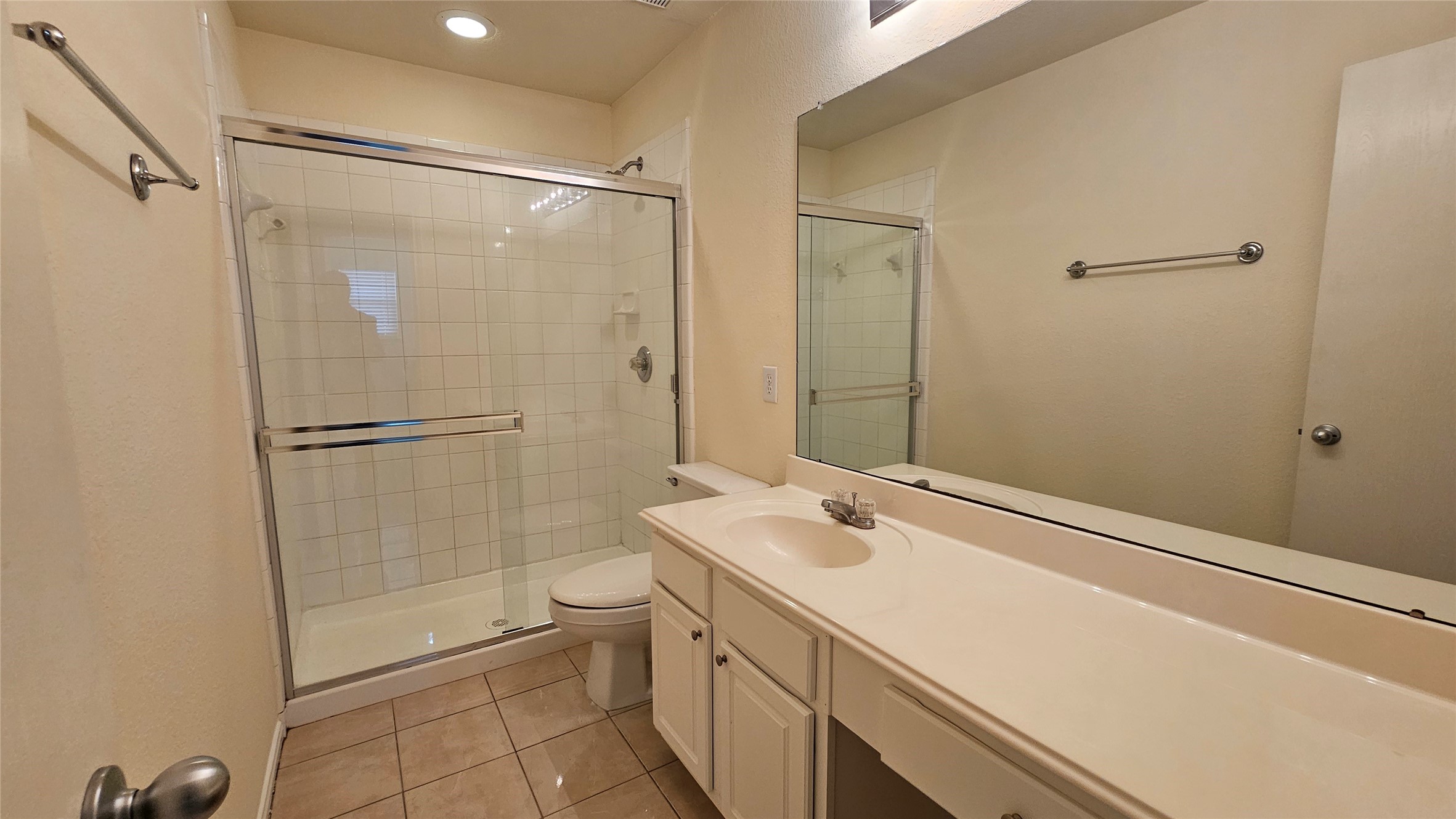 7918 Barnes Ridge Lane Houston, TX 77072 - Photo 19 of 34 This bathroom features a clean and modern design with a large mirror, a spacious vanity, and a glass-enclosed shower. The neutral tile flooring adds a touch of elegance.