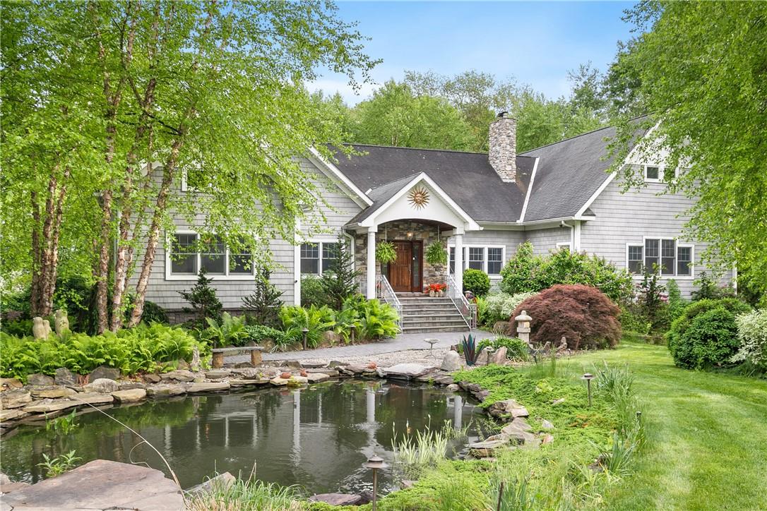 a front view of a house with a yard and potted plants