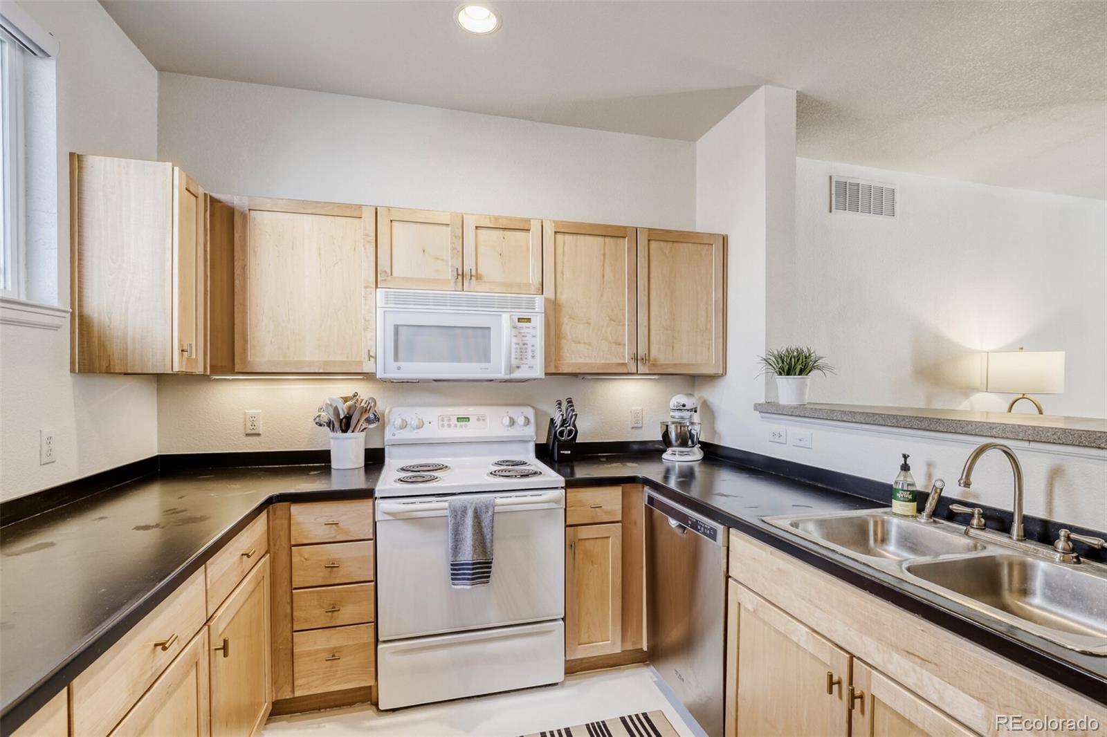 85 Uinta Way, Unit 702 Denver, CO 80230 - Photo 11 of 28 a kitchen with a sink stove and cabinets