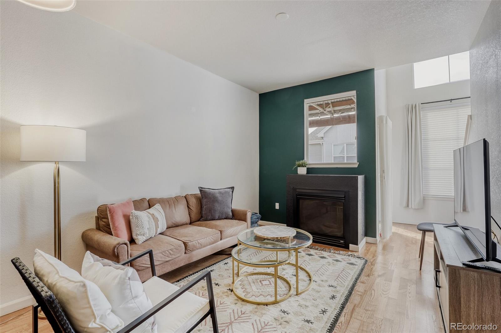 85 Uinta Way, Unit 702 Denver, CO 80230 - Photo 5 of 28 a living room with furniture a fireplace and a flat screen tv