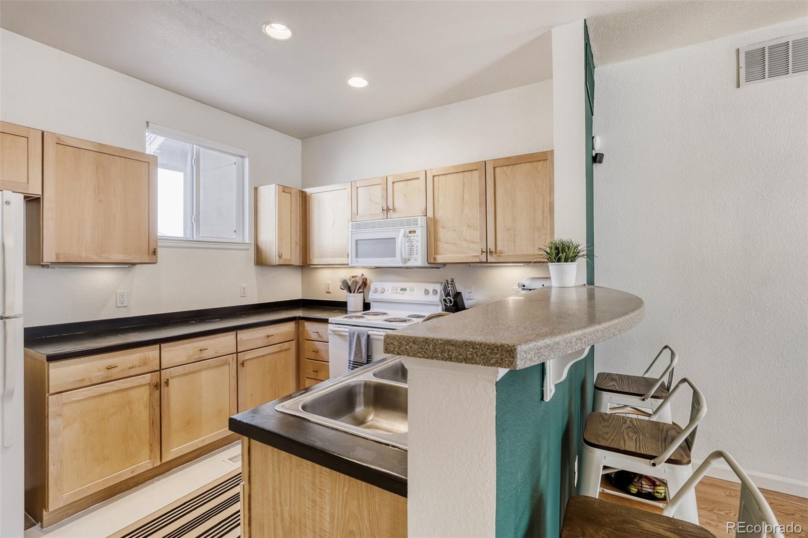 85 Uinta Way, Unit 702 Denver, CO 80230 - Photo 10 of 28 a kitchen with a sink cabinets and window