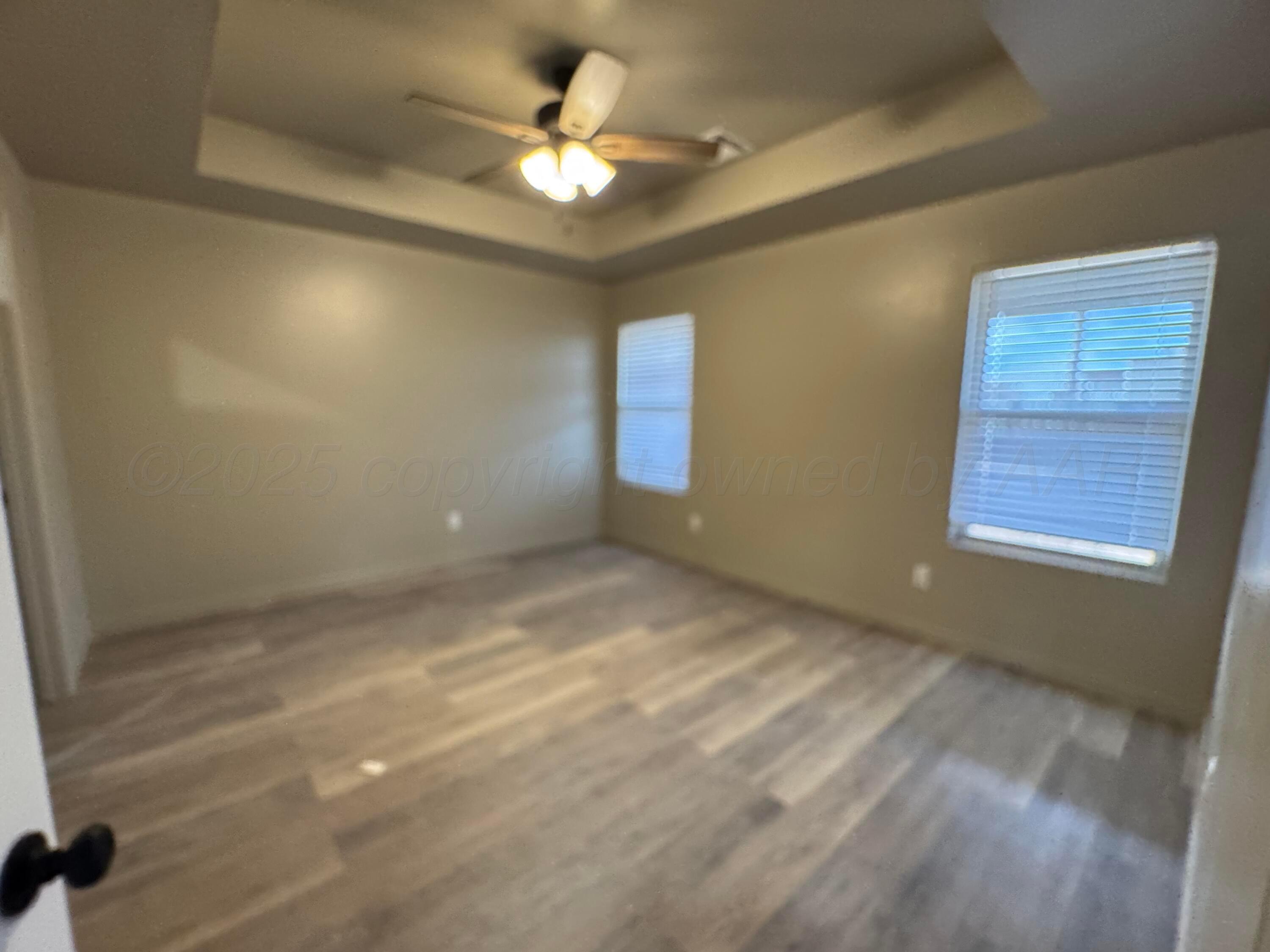 1112 Caprock Street Hereford, TX 79045 - Photo 7 of 10 en empty room with windows and ceiling fan