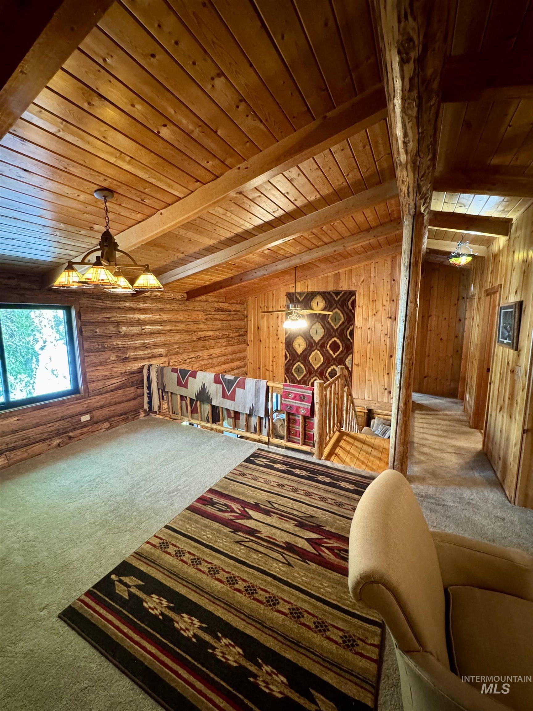 62 Bell Rapids Road Hagerman, ID 83332 - Photo 18 of 34 Vaulted wood-paneled ceiling with exposed beams, wood-plank walls, and natural wood railing overlooking a lower level