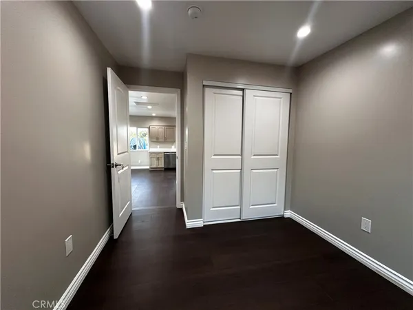 an empty room with wooden floor & windows