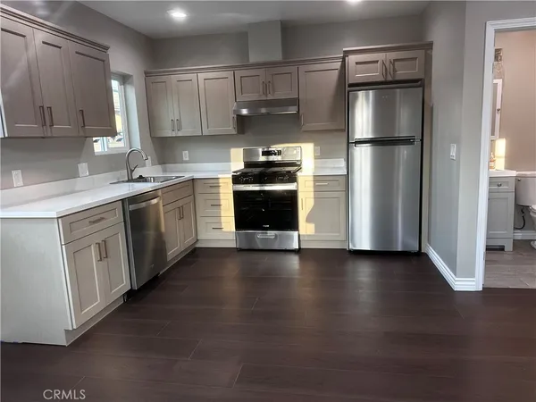 a kitchen with a refrigerator and a stove top oven