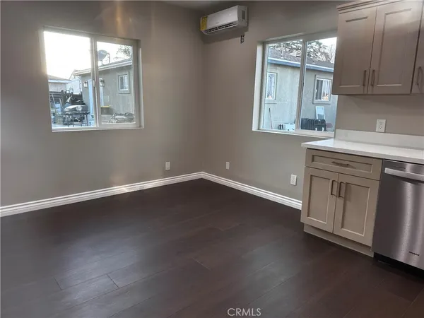 an empty room with wooden floor and window
