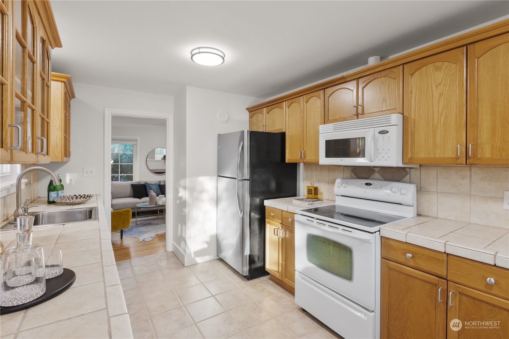 14357 36th Avenue Northeast Seattle, WA 98125 - Photo 7 of 23 a kitchen with a stove a sink and a microwave