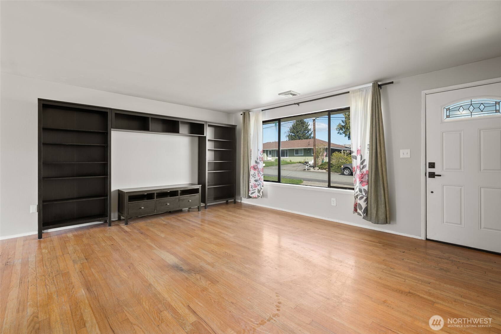 1805 37th Street Anacortes, WA 98221 - Photo 9 of 40 a view of an empty room with wooden floor and a window