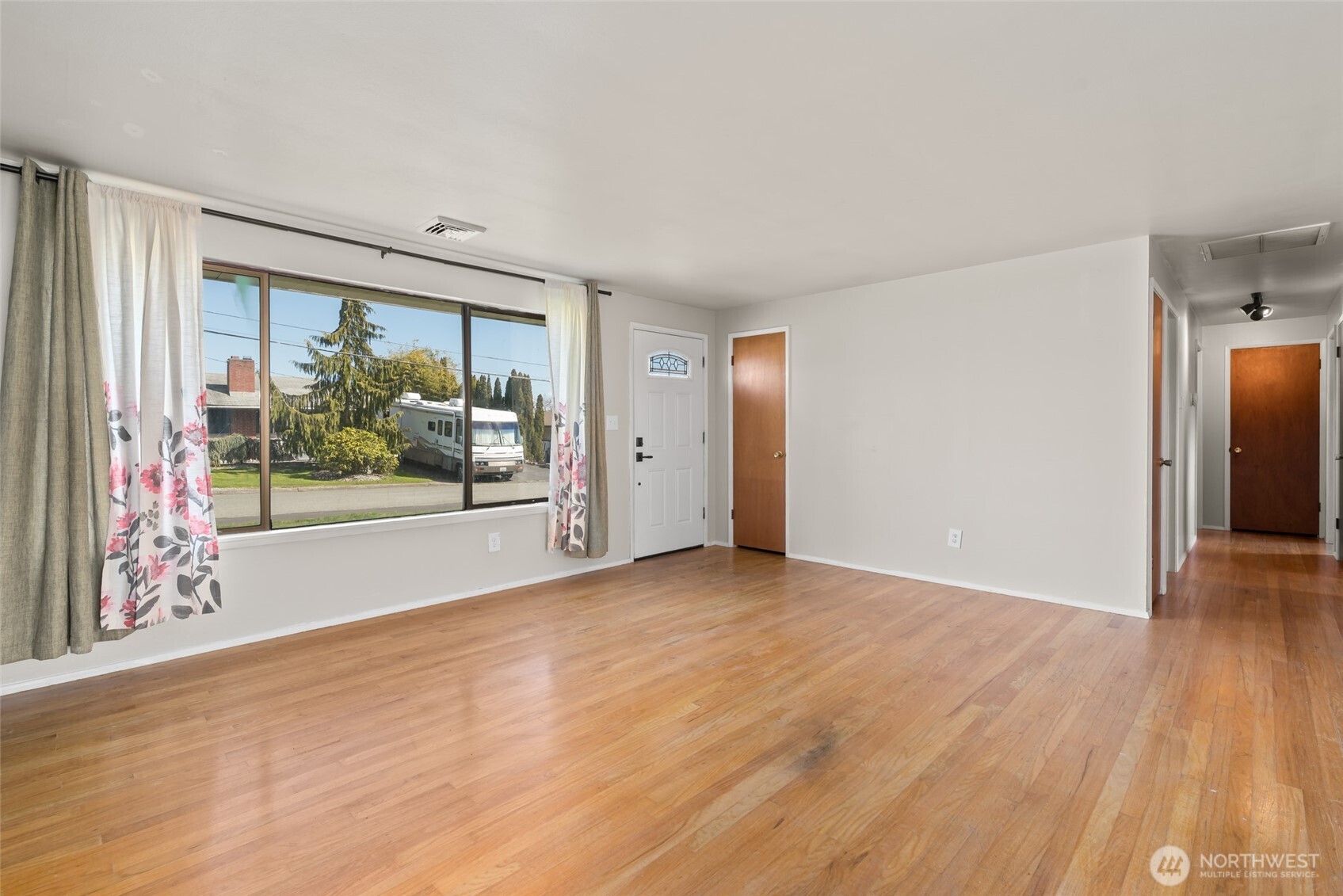 1805 37th Street Anacortes, WA 98221 - Photo 10 of 40 a view of an empty room with wooden floor and a window