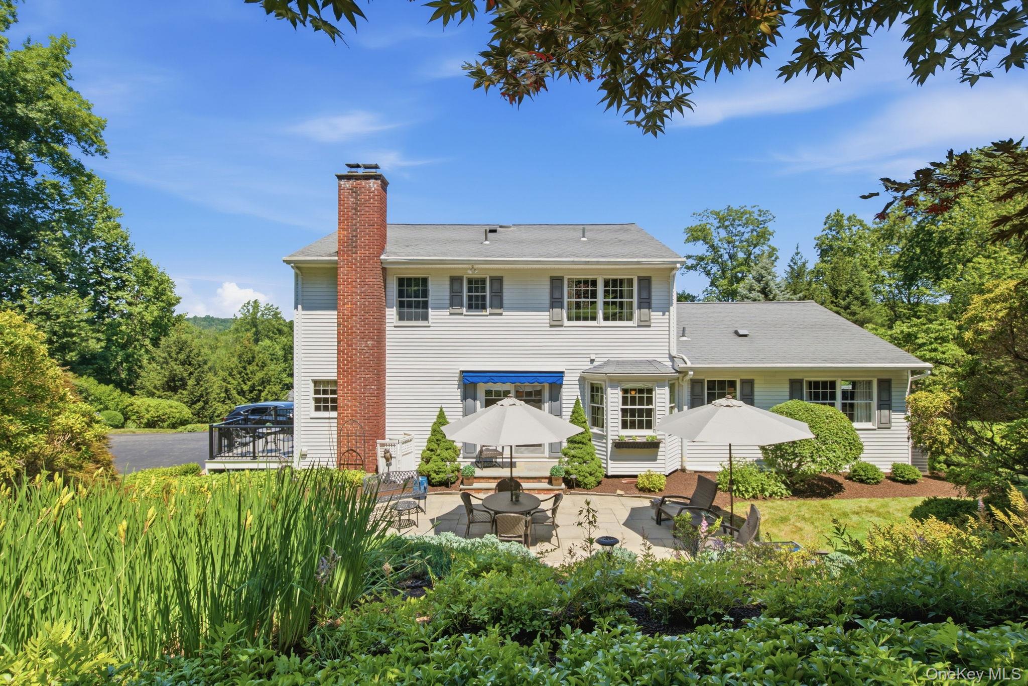 32 Bedell Road Katonah, NY 10536 - Photo 40 of 49 From the gardens, the rear elevation shows off its chimney, bay window, and easy patio connection.