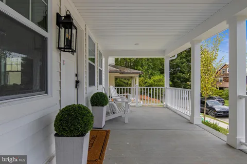 a front view of a house with outdoor seating space and windows