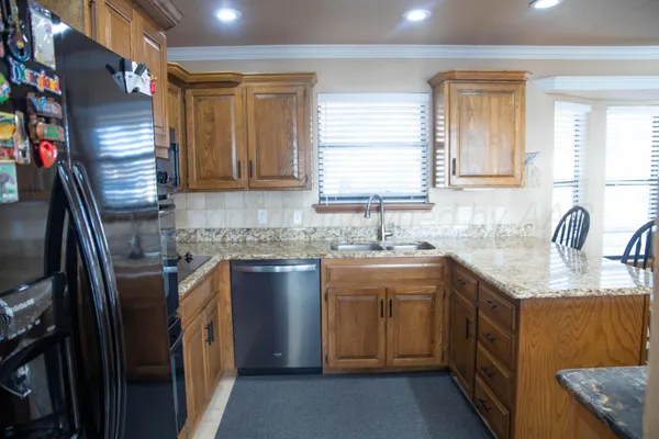 a kitchen with stainless steel appliances granite countertop a sink stove and refrigerator