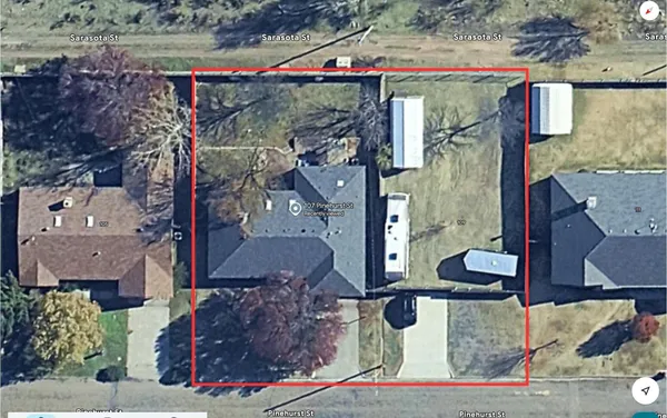 a aerial view of a house with a yard and large trees