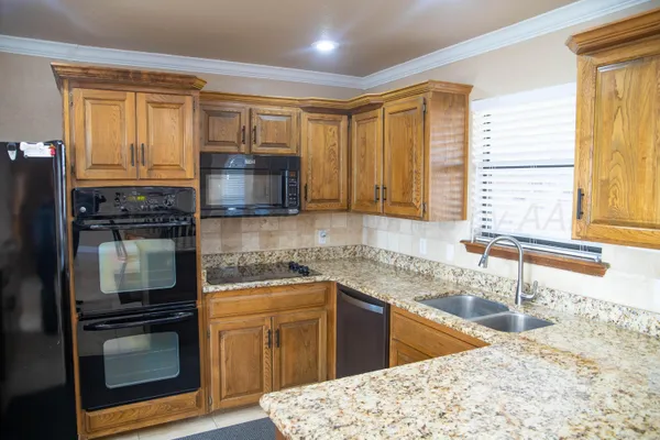 a kitchen with stainless steel appliances granite countertop a stove a sink and a microwave