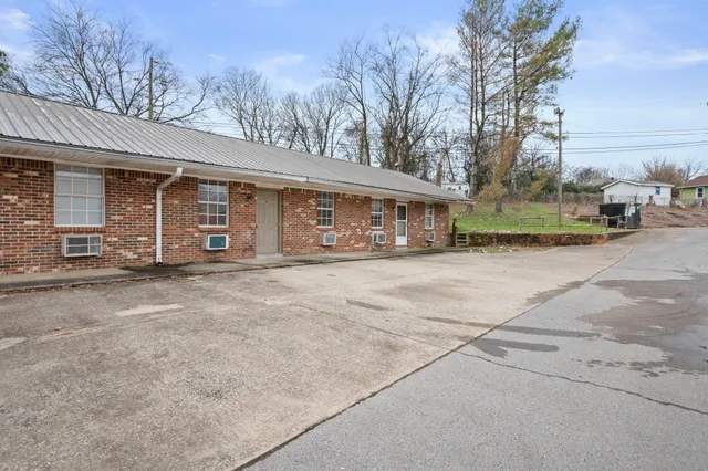 a front view of a house with basket ball court and a yard